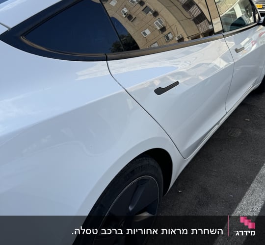 מכונית לבנה עם חלונות כהים וחישוקי גלגלים שחורים